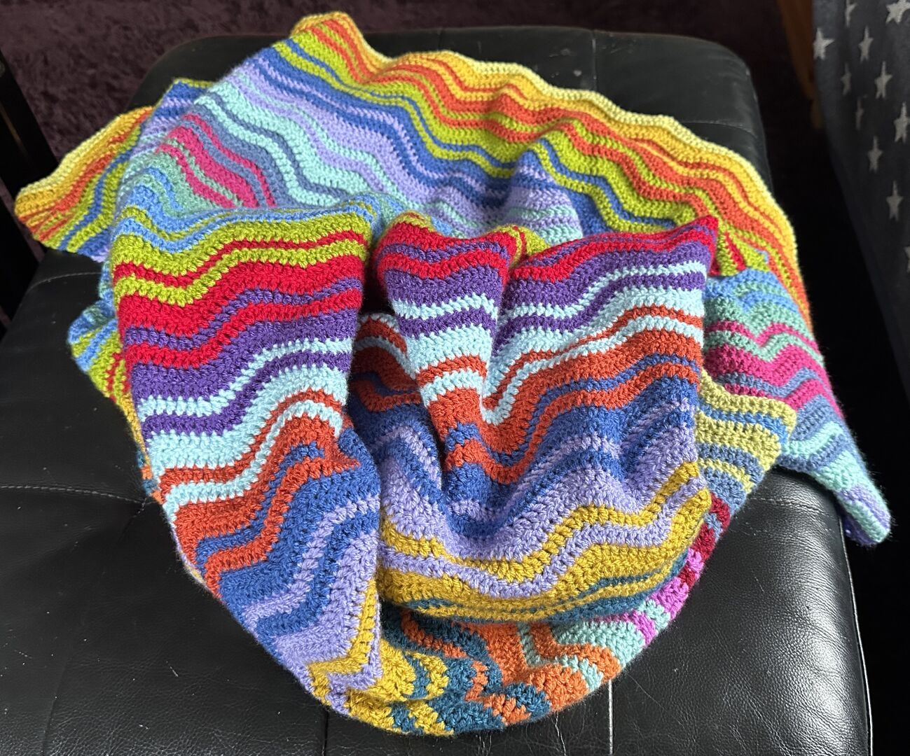 The same blanket in progress scrunched up in a heap to show the colours stripes broken up.