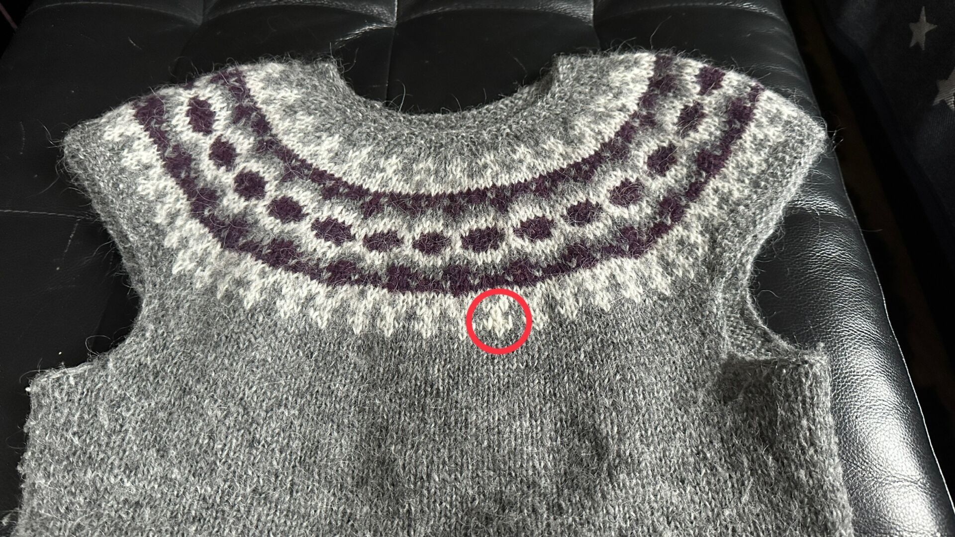 The same vest l now with the mended spot circled in red. It’s in white and a bit to the right from center chest, on the last pattern rows.